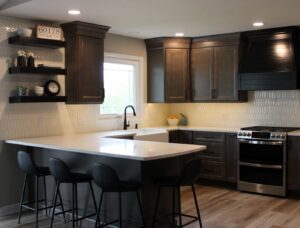 A modern kitchen with dark cabinetry and white countertops