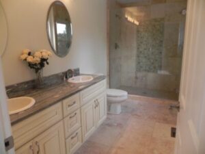 A newly remodeled modern bathroom with a double sink and walk-in shower